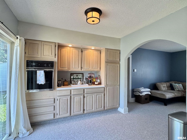 839 E Fremont St, Galesburg, IL 61401 - kitchen with black oven, arched walkways, light carpet, light countertops, and a textured ceiling