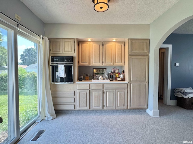 839 E Fremont St, Galesburg, IL 61401 - kitchen with black oven, light carpet, arched walkways, a textured ceiling, and light countertops