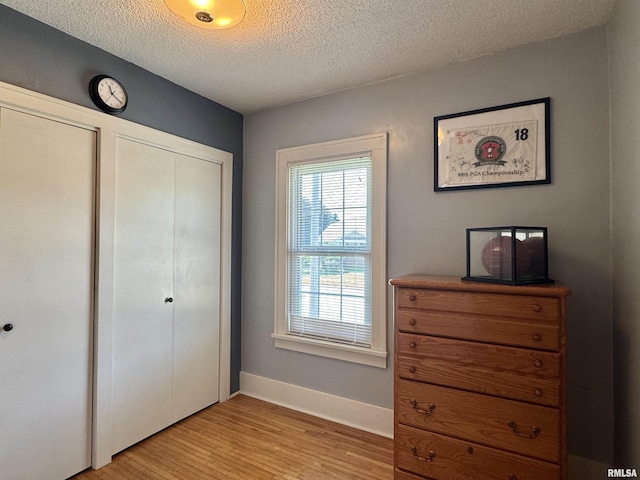 839 E Fremont St, Galesburg, IL 61401 - bedroom featuring light wood-style floors, a textured ceiling, and a closet