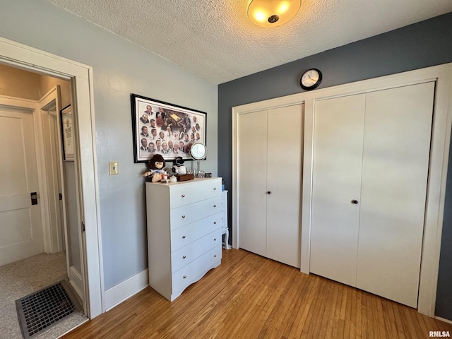839 E Fremont St, Galesburg, IL 61401 - unfurnished bedroom with light wood-style flooring, multiple closets, and a textured ceiling