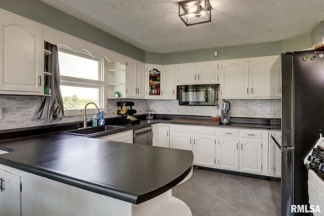 281 N Ave, Plainville, IL 62365 - kitchen featuring stainless steel appliances, dark countertops, a peninsula, a textured ceiling, and decorative backsplash