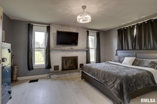 281 N Ave, Plainville, IL 62365 - bedroom featuring wood finished floors, a chandelier, multiple windows, and a textured ceiling