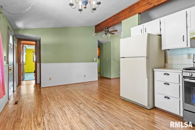 15858 Oak Ln, Girard, IL 62640 - kitchen with freestanding refrigerator, light wood-type flooring, light countertops, stainless steel gas stove, and a chandelier