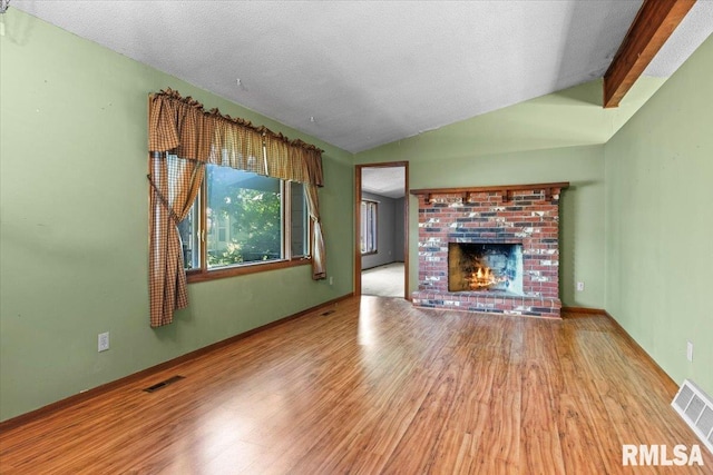 15858 Oak Ln, Girard, IL 62640 - unfurnished living room with lofted ceiling, wood finished floors, and a brick fireplace