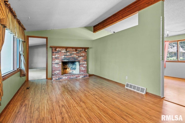 15858 Oak Ln, Girard, IL 62640 - unfurnished living room featuring wood finished floors, a fireplace, and a textured ceiling