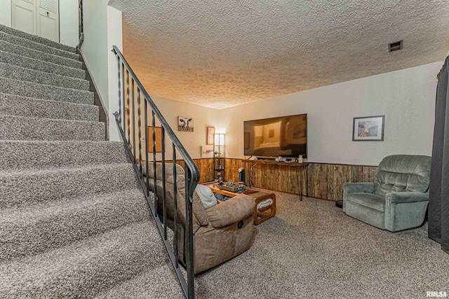 147 Northville Dr, Lincoln, IL 62656 - carpeted living room with a textured ceiling, stairway, a wainscoted wall, and wood walls