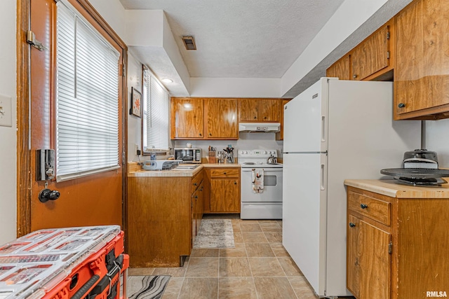 147 Northville Dr, Lincoln, IL 62656 - kitchen featuring white appliances, under cabinet range hood, brown cabinets, a textured ceiling, and tile counters