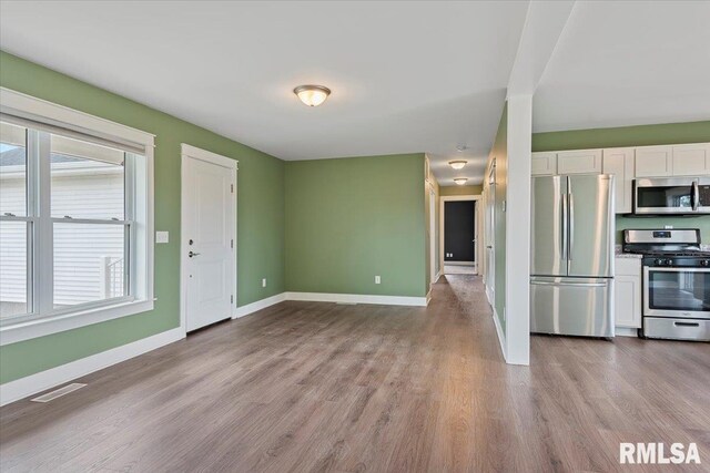 210 Prairie Run, Illiopolis, IL 62539 - kitchen with appliances with stainless steel finishes, white cabinetry, light wood-style floors, and healthy amount of natural light