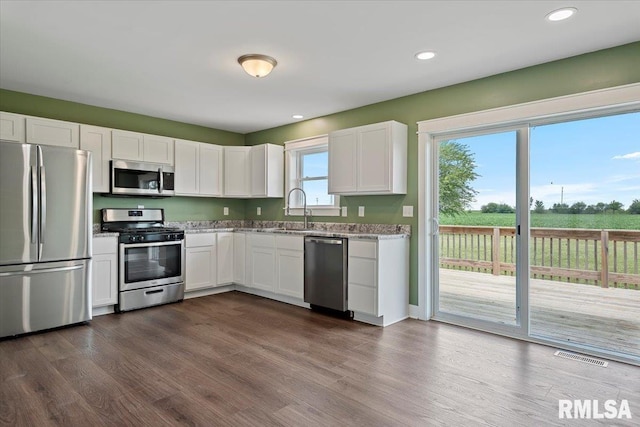 210 Prairie Run, Illiopolis, IL 62539 - kitchen with appliances with stainless steel finishes, white cabinets, dark wood finished floors, light stone countertops, and recessed lighting