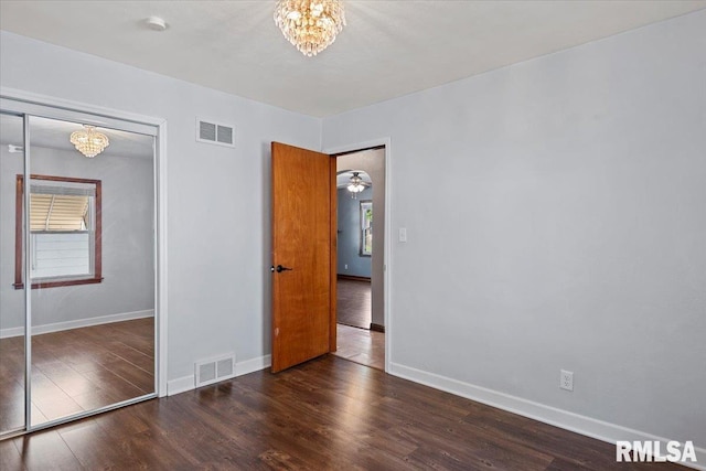 2912 E Enos Ave, Springfield, IL 62702 - unfurnished bedroom featuring a chandelier, wood finished floors, and a closet
