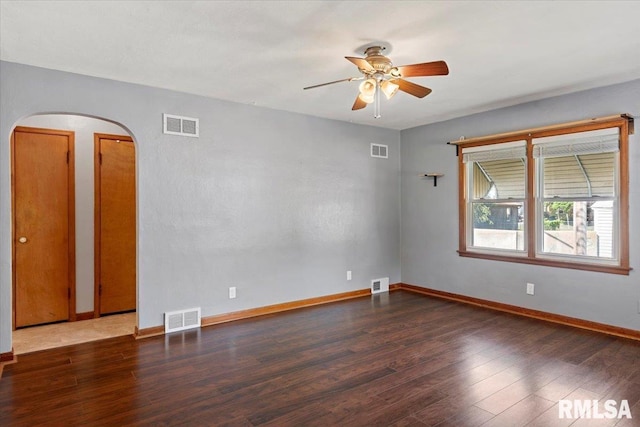 2912 E Enos Ave, Springfield, IL 62702 - empty room featuring arched walkways, a ceiling fan, and wood finished floors