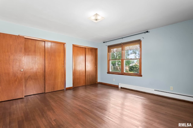 113 W Walnut St, Chatham, IL 62629 - unfurnished bedroom with two closets, wood finished floors, and a baseboard radiator