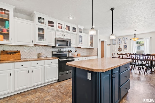 16540 Wernowsky St, Petersburg, IL 62675 - kitchen featuring appliances with stainless steel finishes, white cabinetry, backsplash, a textured ceiling, and hanging light fixtures