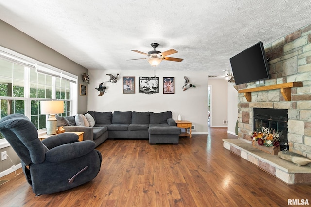 16540 Wernowsky St, Petersburg, IL 62675 - living area with wood finished floors, ceiling fan, a stone fireplace, and a textured ceiling