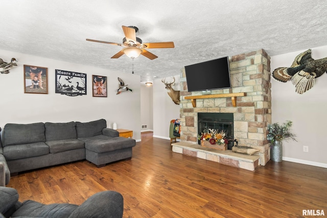 16540 Wernowsky St, Petersburg, IL 62675 - living area featuring ceiling fan, a textured ceiling, wood finished floors, and a stone fireplace