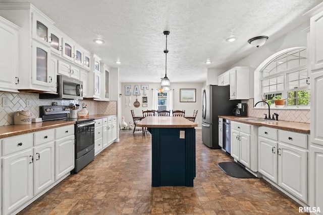 16540 Wernowsky St, Petersburg, IL 62675 - kitchen with appliances with stainless steel finishes, a center island, white cabinetry, a textured ceiling, and plenty of natural light