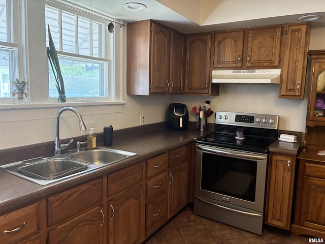 700 S 20th St, Quincy, IL 62301 - kitchen featuring stainless steel range with electric stovetop, under cabinet range hood, dark countertops, dark tile patterned flooring, and brown cabinets
