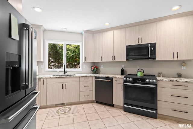 4905 Eagles Lndg, Springfield, IL 62711 - kitchen with black appliances, light brown cabinets, light stone countertops, light tile patterned floors, and recessed lighting