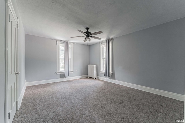 418 E Cooke St, Mount Pulaski, IL 62548 - empty room featuring radiator, a ceiling fan, carpet, and a textured ceiling