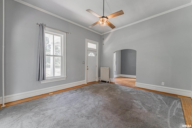 418 E Cooke St, Mount Pulaski, IL 62548 - entryway featuring radiator heating unit, crown molding, arched walkways, ceiling fan, and wood finished floors