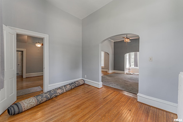 418 E Cooke St, Mount Pulaski, IL 62548 - empty room featuring high vaulted ceiling, arched walkways, a ceiling fan, and hardwood / wood-style flooring