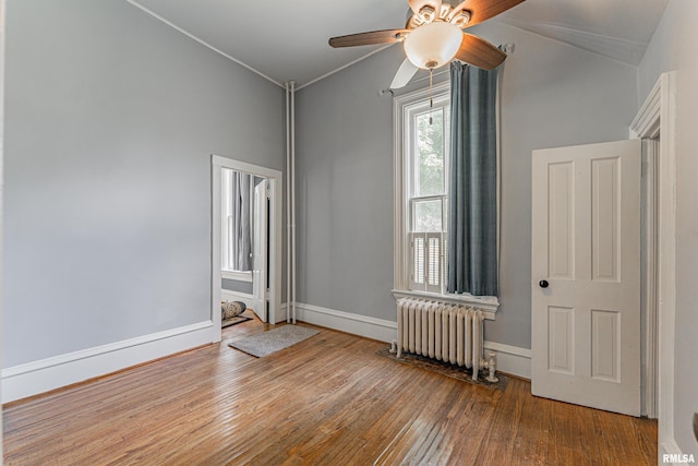 418 E Cooke St, Mount Pulaski, IL 62548 - spare room with radiator heating unit, wood-type flooring, lofted ceiling, and a ceiling fan