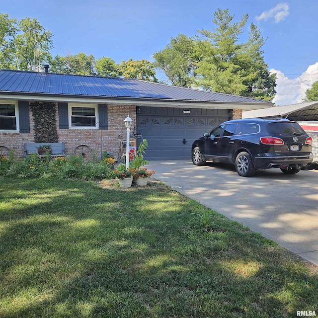 704 N Cherry St, Abingdon, IL 61410 - view of front of house with brick siding, concrete driveway, an attached garage, a metal roof, and a front yard