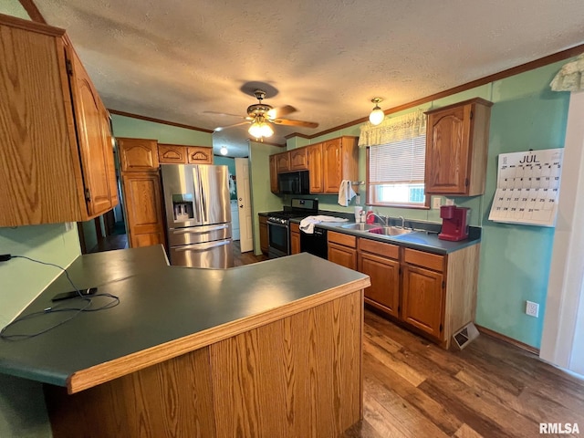 517 S Obannon St, Raymond, IL 62560 - kitchen with stainless steel appliances, ornamental molding, a peninsula, dark wood-type flooring, and a textured ceiling