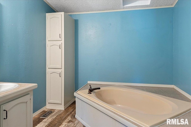 913 Springfield St, Kincaid, IL 62540 - full bath with a garden tub, wood finished floors, vanity, a textured ceiling, and a textured wall