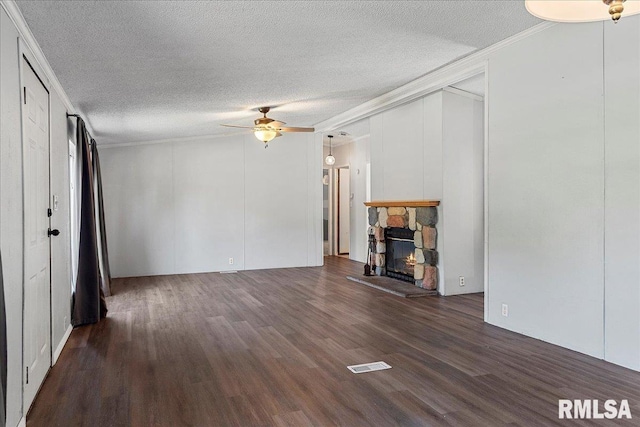 913 Springfield St, Kincaid, IL 62540 - unfurnished living room featuring crown molding, a ceiling fan, dark wood-style floors, a textured ceiling, and a stone fireplace