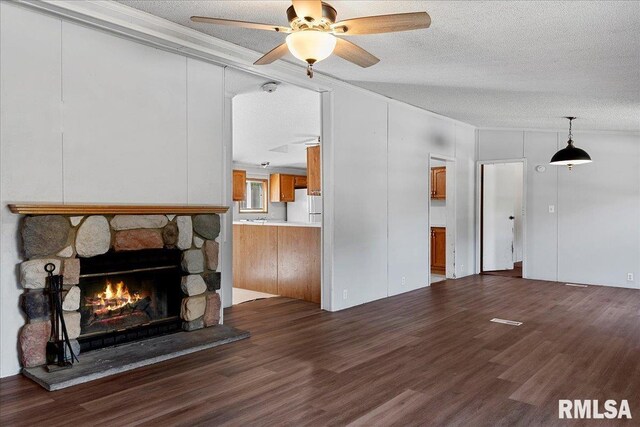 913 Springfield St, Kincaid, IL 62540 - living area with ornamental molding, dark wood-type flooring, a textured ceiling, a ceiling fan, and a stone fireplace