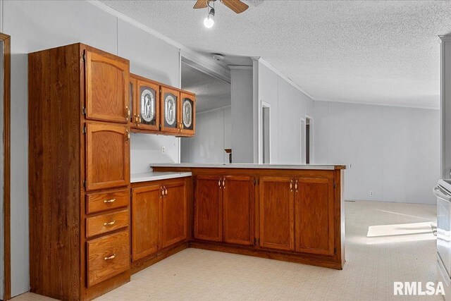 913 Springfield St, Kincaid, IL 62540 - kitchen with a peninsula, crown molding, light countertops, brown cabinetry, and ceiling fan