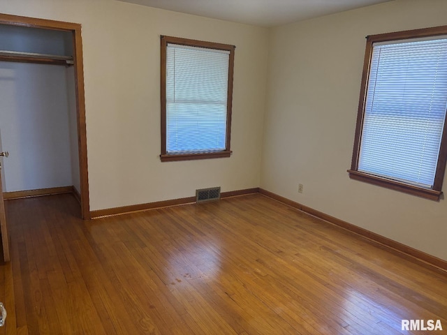 2308 S Whittier Ave, Springfield, IL 62704 - unfurnished bedroom featuring wood-type flooring, a closet, and multiple windows