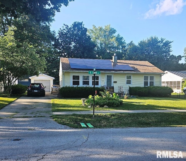 707 E Clark St, Litchfield, IL 62056 - view of front of house with roof mounted solar panels, a front yard, a detached garage, an outdoor structure, and driveway