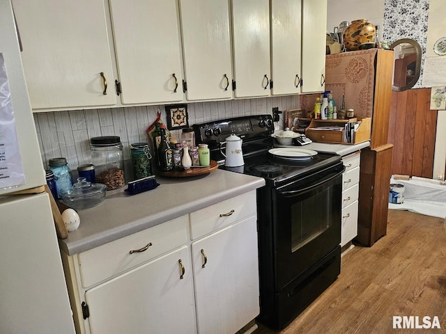 707 E Clark St, Litchfield, IL 62056 - kitchen featuring black range with electric cooktop, freestanding refrigerator, white cabinets, light countertops, and light wood-style flooring