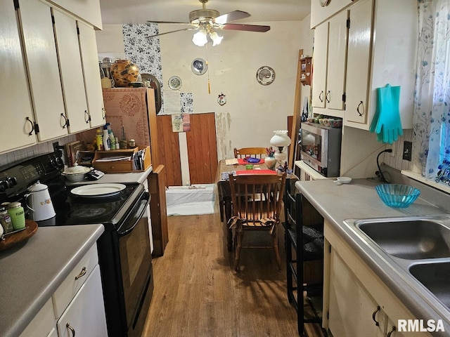 707 E Clark St, Litchfield, IL 62056 - kitchen featuring black range with electric cooktop, dark wood-style floors, a ceiling fan, stainless steel microwave, and white cabinets