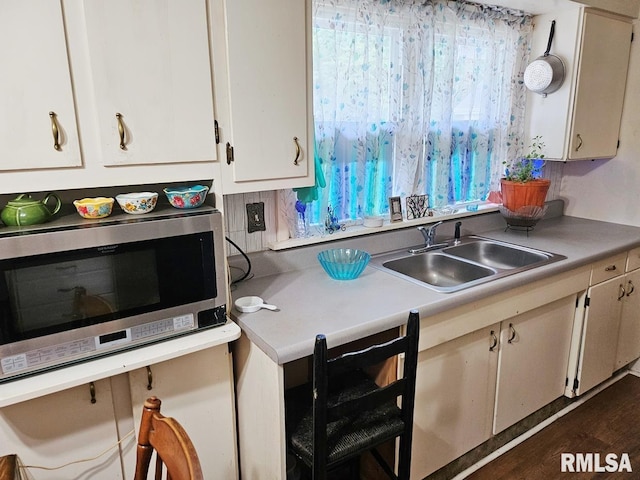 707 E Clark St, Litchfield, IL 62056 - kitchen with stainless steel microwave, white cabinetry, light countertops, and dark wood-type flooring