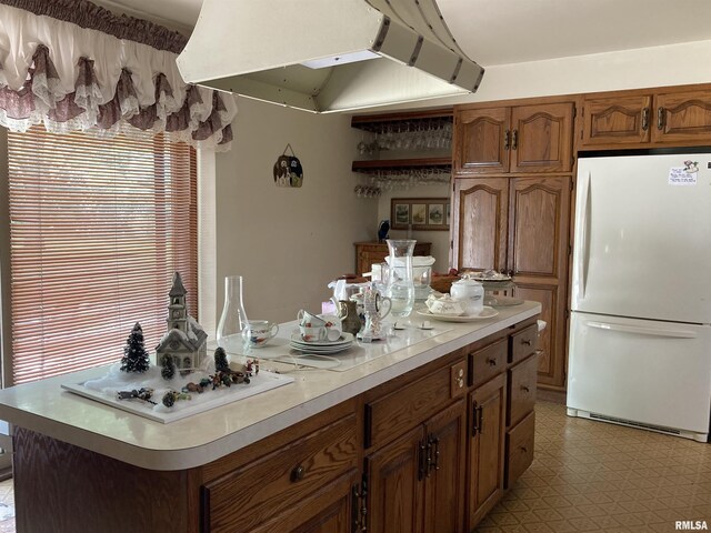 604 Knox Rd N Unit 1000, Gilson, IL 61436 - kitchen with freestanding refrigerator, range hood, light countertops, light floors, and brown cabinets