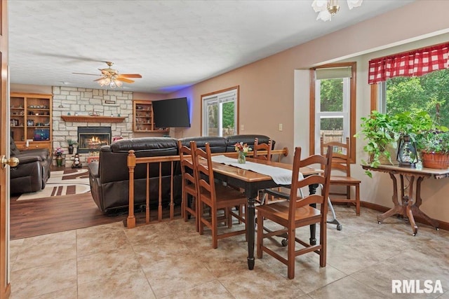 1420 Weston Pointe Dr, Springfield, IL 62704 - dining space with a ceiling fan, a textured ceiling, a stone fireplace, and built in shelves