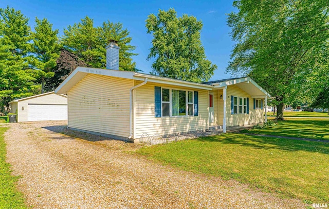 913 N Flora Dr, Mount Pulaski, IL 62548 - view of front facade with an outdoor structure, a front lawn, a chimney, and a detached garage