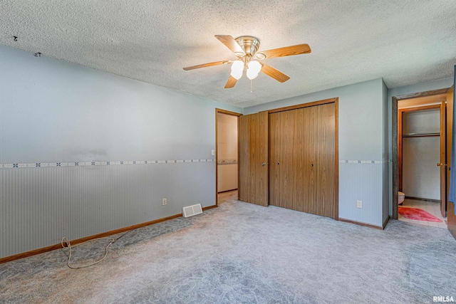 913 N Flora Dr, Mount Pulaski, IL 62548 - unfurnished bedroom with a closet, carpet, a textured ceiling, and a ceiling fan