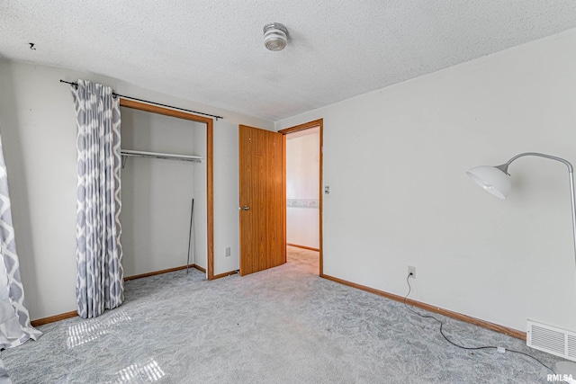 913 N Flora Dr, Mount Pulaski, IL 62548 - unfurnished bedroom featuring carpet, a closet, and a textured ceiling