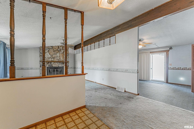 913 N Flora Dr, Mount Pulaski, IL 62548 - unfurnished living room featuring ceiling fan, a fireplace, carpet flooring, a textured ceiling, and tile patterned floors