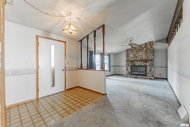 913 N Flora Dr, Mount Pulaski, IL 62548 - carpeted foyer entrance featuring a ceiling fan, a textured ceiling, a stone fireplace, and lofted ceiling
