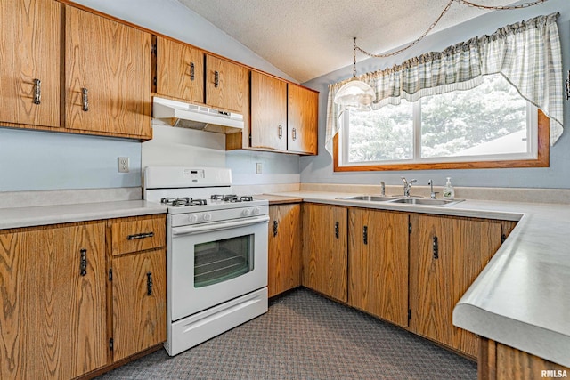 913 N Flora Dr, Mount Pulaski, IL 62548 - kitchen featuring under cabinet range hood, white range with gas cooktop, vaulted ceiling, light countertops, and brown cabinetry