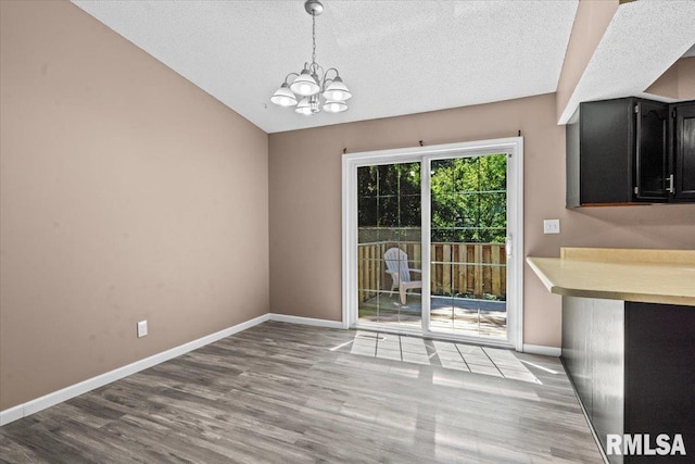 913 Diane Ct, Springfield, IL 62702 - unfurnished dining area featuring a chandelier, wood finished floors, a textured ceiling, and vaulted ceiling