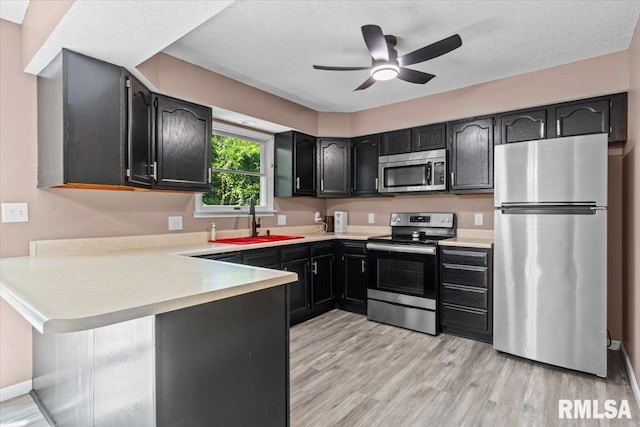 913 Diane Ct, Springfield, IL 62702 - kitchen with stainless steel appliances, a peninsula, light wood-style flooring, ceiling fan, and light countertops