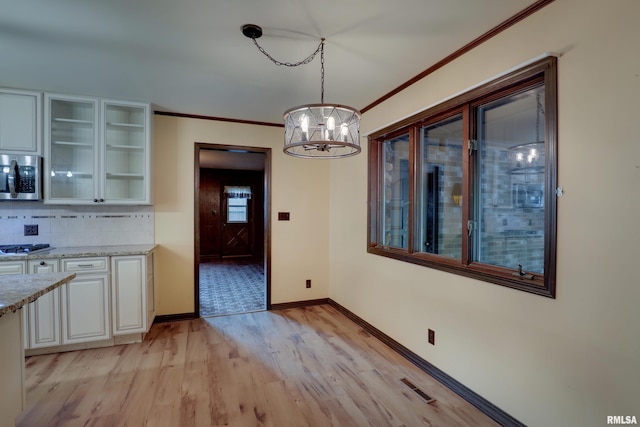 1220 Springdale S Dr, Quincy, IL 62305 - unfurnished dining area featuring a chandelier, light wood-type flooring, and ornamental molding