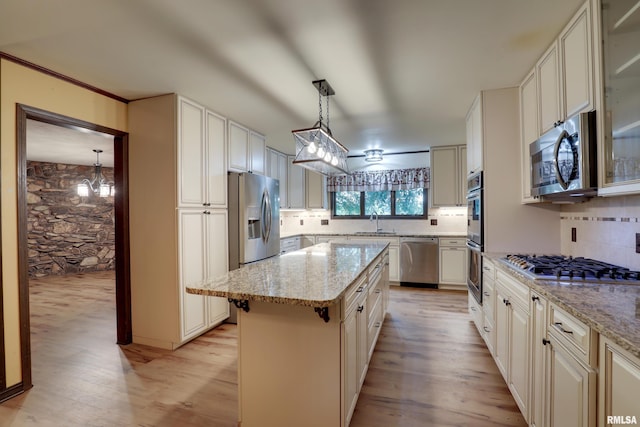 1220 Springdale S Dr, Quincy, IL 62305 - kitchen featuring appliances with stainless steel finishes, light wood-style floors, decorative backsplash, and a kitchen island