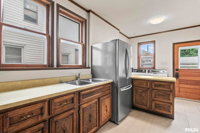417 E Keys Ave, Springfield, IL 62702 - kitchen with crown molding, freestanding refrigerator, light countertops, light tile patterned floors, and washing machine and dryer